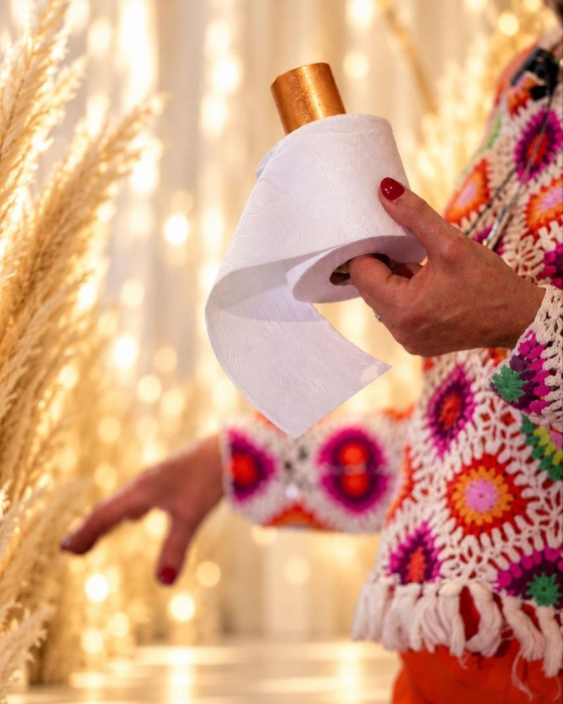 Ihre Hände mit einer goldenen Klangschale vor Pampasgras.